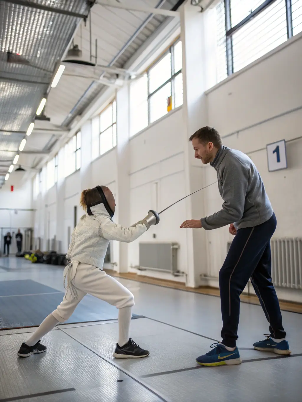 A photo of a fencing coach providing one-on-one instruction to a fencer, focusing on technique and strategy. The coach is offering personalized feedback and guidance.